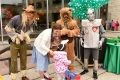 Des personnages du Magicien d’Oz distribuent des bonbons à un enfant