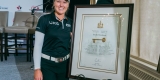 Brooke Henderson standing beside framed Key to the City plaque