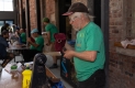 Un bénévole de l’Ottawa Tool Library, vêtu d’un t-shirt vert et d’une casquette noire, examine un couteau de cuisine. 