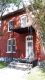 Cette maison en brique rouge et à toit plat située au 143, rue Murray, dans le district de conservation du patrimoine du marché By, présente des ornements de style italien, y compris des voussoirs en brique et une corniche décorative. 